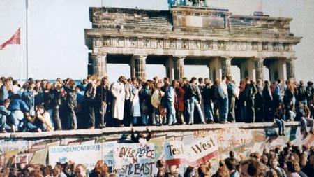 West and East Germans on top of the Berlin Wall at the Brandenburg Gate