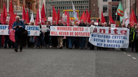 Protest in Dublin city center, people with large banners that read "workers united will never be defeated"
