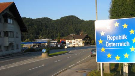Road at Austrian Schengen Border with blue sign that reads "Republik Osterreich" surrounded by EU's yellow stars
