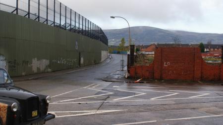 Belfast Peace wall, a high fence and cloudy skies