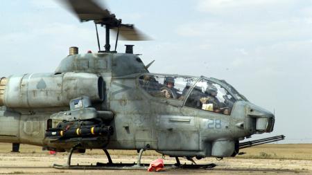 Large cobra helicopter on sandy ground