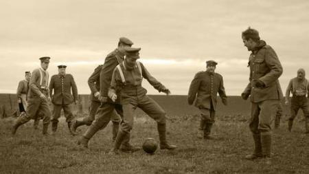Sepia-tone photo of men playing football together.